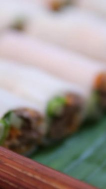Vietnam börekleri - gi cun - içinde taze karides, pirinç eriştesi, salatalık, yeşil muz yaprağına yerleştirilmiş otlar, canlı renkler ve dokular var. Yüksek kalite 4k görüntü