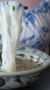 Lokantada beslenme, öğle ve akşam yemeklerini sebze ve erişteyle birlikte yemek, el ve ramen kasesi yemek. Müşteri, insan ve yemek çubukları sağlıklı yemek ve geleneksel Japon mutfağı için.