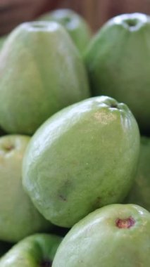 Tahta bir masanın üzerindeki tahta kesme tahtasındaki taze kesilmiş guava manzarası. Seçici odak bulanık arkaplan. Yüksek kalite 4k görüntü