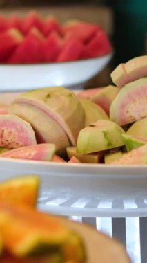 Karpuz, mango, papaya ve ananas da dahil olmak üzere taze dilimlenmiş tropikal meyveler tabakta, sağlıklı beslenme ve yaz içeceğini betimliyor. Sağlıklı beslenme ve yaşam tarzı. 4k