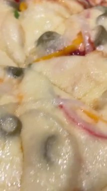 Salamlı, zeytinli ve peynirli iki yuvarlak pizza ve yanında iki soslu gri bir masa ve dokusu daha yakın. Yüksek kalite 4k görüntü