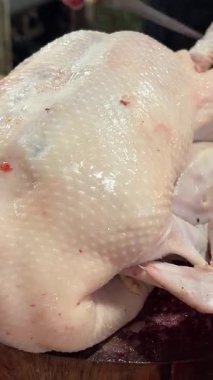 Doğranmış taze tavuk filetosu kesim tahtasının üzerinde, yakın planda taze tavuk eti parçalarının çoğu kağıt üzerinde duruyor. Yüksek kalite 4k görüntü