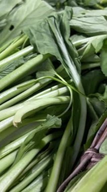 Çok sayıda Napa lahanası, kereviz sapı ve yapraklı yeşillikleriyle pancar kökü içeren taze ürünlerin sergilendiği bir market tezgahının yakın plan görüntüsü. Yüksek kalite 4k görüntü