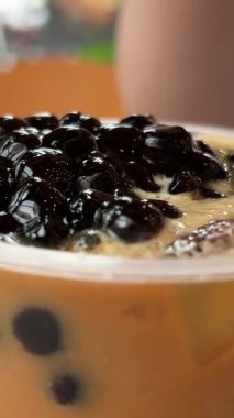 Kadın buzlu sütlü çay içiyor. Kahveye topioca ekle