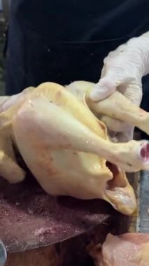 Markette tavuk yapmak eldivenli bir kadının tavuk leşini doğraması şehirdeki gerçek insanları gerçek zamanlı olarak dışarı çıkarması da nang vietnam 07.17.2025