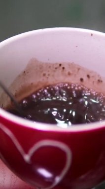 Sıcak çikolatalı Stirs Sugar 'ı Aromatik Kahve Fincanı' nda karıştırmak. Kişi Eli Karıştıran Sıcak Çikolata. Taze Sabah Kahvesi. Yakın çekim. Ağır çekim. Süt Sıcak Çikolatası Beyaz Kupada. 