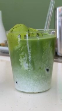 Matcha, Tayland 'daki Choui Fong Çay Çiftliği' nin ünlü turistik merkezinde bir masada buzlu yeşil çay, sütlü çay ve yeşil çay keki içer. Yüksek kalite 4k görüntü