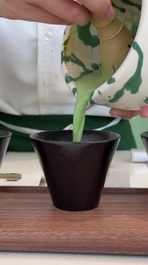 Geleneksel çay seremonisi ortamında ahşap bir tepside sunulan üç kase canlı yeşil kibrit kutusu ile güzel bir eşleşen çay seti. - Evet. Yüksek kalite 4k görüntü