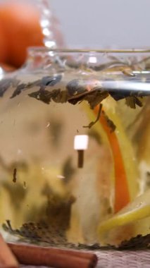 Çaya bir portakal dilimi at. Citrus, Closeup, Glass Teapot, Lemon and Lime at Table ile Nane Yaprakları koy. Yüksek kalite 4k görüntü