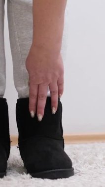 Kadın elleriyle yeni kış ayakkabıları giyer. Yüksek kalite 4k görüntü