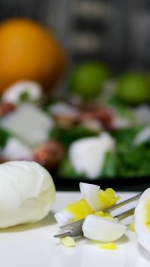 Bir şefin elleri mutfakta bir kesme tahtasının üzerinde haşlanmış yumurta doğruyor. Yüksek kalite 4k görüntü