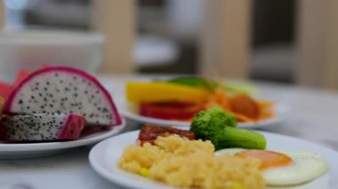 Masadaki beyaz tabakta, pahalı bir otel omletinde kahvaltı. Ejderha meyveli ekmek meyvesi. Yüksek kalite 4k görüntü