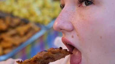 Dilimlenmiş Asya mutfağının tadını çıkaran bir turist kadın. Şehir caddesinde pizza yiyen modaya uygun bir kadın. 4 bin. Yüksek kalite 4k görüntü