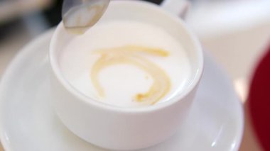 Tanımlanamayan Kafkasyalı garson erkek garsonun elleri yakın çekimde müşteriler için sütlü latte içiyor profesyonel adam kafeteryada lezzetli bir içecek siparişi hazırlıyor.