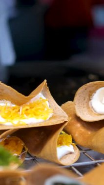 Tayland sokak aşçıları Khanom Bueang 'ı, Çıtır Tayland Krepleri, Sıcak Griddle' dan Tayland Tacoları ve Gece Marketinde Soğutma Rafına Yerleştirme, Tatlı Atıştırmalıkları. Yüksek kalite 4k görüntü