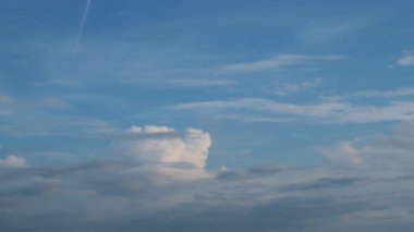 Işık bulutları gökyüzünde kayar. Mavi gökyüzündeki bulutlar zıt yönde yatay hareket ediyor. Yüksek kalite 4k görüntü