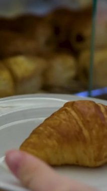 Cam tepside dört kruvasan kapaklı tabak başına bir tane seç. Yüksek kalite 4k görüntü