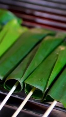 Otak-otak, muz yapraklarına sarılmış un ve uskumrudan yapılmış bir yiyecek. Izgarayla pişirilmiş. Bir otak-otak satıcısı yemeğini kızartırken görülmüş. Yüksek kalite 4k görüntü