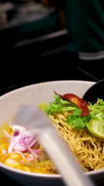 Kavrulmuş yumurta ve sebzeli hazır şehriye çorbası, kaşık ve çatalla geleneksel Endonezya yastığında lahana. Lokantada kaşık çubuğu ve Asya eriştesi servis et.