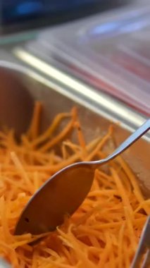 Yumurta ruloları, taze rendelenmiş kırmızı havuç yığınıyla birlikte açık havada ahşap bir kesme tahtasının üzerinde, pişirme ve servis için hazır. Yüksek kalite 4k görüntü