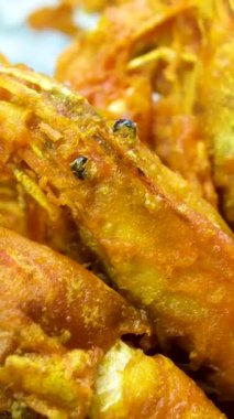 Kızarmış altın renginde karides tempurası. Parlak doğal ışıkta kırmızı sosla güzelce düzenlenmiş. Yüksek kalite 4k görüntü