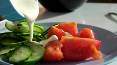 Sezar salatasına sos dök. Kamera kaydırma görüntüsü. Salatalıklar krema sosu döker.