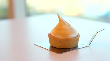 Kremalı altın-kahverengi kabuk ve kabarık beyaz kaplama beyaz bir tabakta, kaşıkla. Dikey çekim. Yüksek kalite 4k görüntü