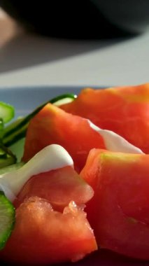 Sezar salatasına sos dök. Kamera kaydırma görüntüsü. Salatalıklar krema sosu döker.