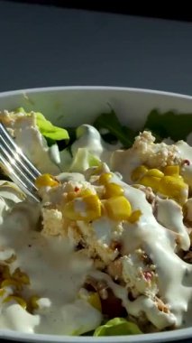 Salata çatal soslu salata, ton balığı, mısır, parmesan peyniri, domates, kızarmış ekmek, marul yaprağı, keten tohumu, ayçiçeği ve susam tohumlu. Yüksek kalite 4k görüntü