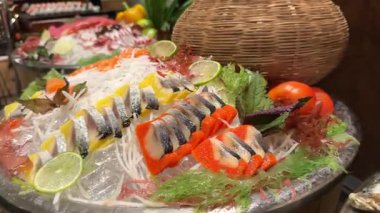 Japon suşi tabağından bir dilim ton balıklı sashimi. Stüdyo ışıkları altında siyah bir arka planda somon, deniz tarağı, yumurta ve garnitürle. Yüksek kalite 4k görüntü
