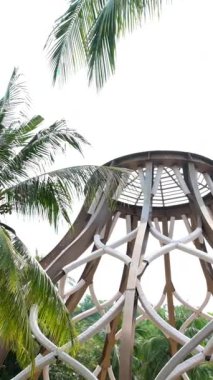 Hindistan cevizi ağaçlarının altındaki bir binanın çatısından yağmur damlaları düşer. Yüksek kaliteli FullHD görüntüler