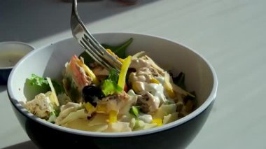 Papyonlu makarna salatası ve konserve ton balığı, havuç, soğan, mısır, domates, bezelye ve beyaz tabakta mayonez sosu. Yüksek kalite 4k görüntü