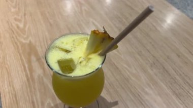 El, sarı ananaslı zencefilli limonlu içeceği taze nane ile karıştırıp dekore ediyor. Dikey video. Sağlıklı ev yapımı karışımı. Yüksek kalite 4k görüntü