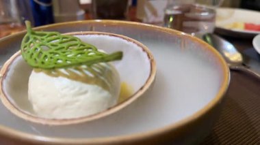 Kuru buz garsonu lüks restoran masasında bulaşık kapağını dumanla sunuyor. Süslü bir kafede saat açılıyor. Yoksul insan güzel bir yerde akşam yemeği yiyor. Yemek nefis. 