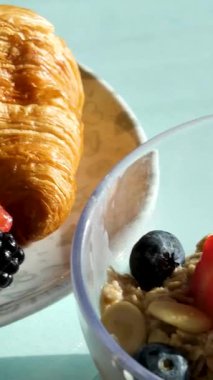 Haşlanmış yumurtalarla kahvaltı. Üst manzara, rotasyon. Kruvasan böğürtlen tabağı