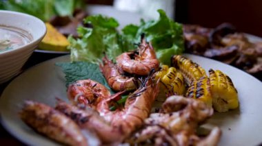 Izgara deniz ürünleri ve limon dilimleri ve soslu et tabağı..