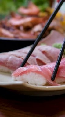 Suşi Sashimi Nigiri Tabağı, Japon gunkan maki suşi restoranı, Taze Ton Balığı ve Somon Dilimleri modern kafede, geleneksel yemekler, çiğ kırmızı balık tabağı, omega 3. Yüksek kalite 4k görüntü