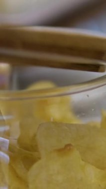 Kavanoz kapağı kapağı, kaseden cips yerken. Sağlıksız patates cipsi yiyen bir kadın. Atıştırmalık bir şeyler. Çocuk Fast Food yiyor, evde abur cubur yiyor, televizyon seyrediyor. Çocukluk obezitesi. Yüksek kalite 