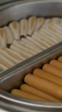 Festival standında sosis pişirirken ve sosis pişirirken çekilmiş yakın plan bir fotoğraf. Yüksek kalite 4k görüntü