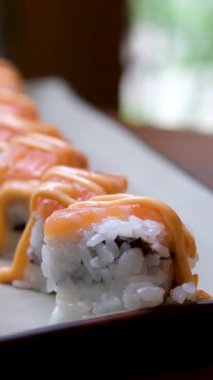 Chopstickler Japon restoranında Japon suşisi yer. Geleneksel suşi Maki Rolls Suşi Suşi Salmon Philadelphia Peyniri Avokado, Salatalık, Pirinç ve Nori. Japon Suşi Roll Uramaki, Nigiri ve Hosomaki