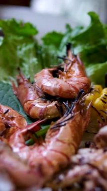 Karışık mısır ve deniz ürünleri barbeküsü. Barbeküde kızarmış mısır ve tavuk. Izgara karidesler karides çevirildiğinde ızgarada cızırdıyor. Izgara deniz ürünleri mısırı.