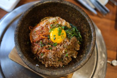 Biftek ve sosla birlikte pirinç üzerine serpiştirilmiş sahanda yumurta sarısı..