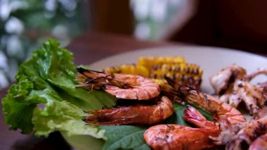 Karışık mısır ve deniz ürünleri barbeküsü. Barbeküde kızarmış mısır ve tavuk. Izgara karidesler karides çevirildiğinde ızgarada cızırdıyor. Izgara deniz ürünleri mısırı.