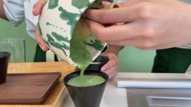 Adım adım Japon çayı yapmayı öğretiyorum. Beşinci adım, kibrit çayını bardağa dök, içkinin tadını çıkar. Yüksek kalite 4k görüntü