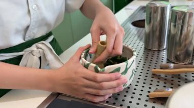 Adım adım Japon çayı yapmayı öğretiyorum. Beşinci adım, kibrit çayını bardağa dök, içkinin tadını çıkar. Yüksek kalite 4k görüntü