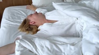 İki taraflı aynanın önünde çarşaf maskesi takan bir kadın. Beyaz bornozlu güzel bir kız elinde kahve ya da çay bardağıyla oturuyor. Rahatla ve rahatla. Önünde bir sürü kozmetik var. .