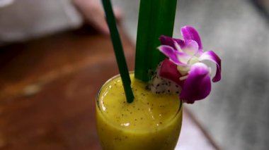 Cam kavanozda, mavi arka planda mangolu yoğurtlu smoothie dolduruyorum. Soğuk ve sağlıklı karışımlı Mango Lassi. Yüksek kalite 4k görüntü