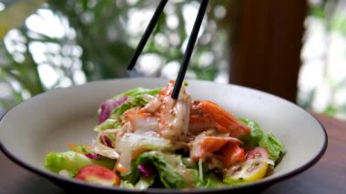 Baharatlı acı biber soslu, fıstıklı, susamlı ve kırmızı biberli lahanalı, mavi kenarlı, yemek çubuklarıyla kızartılmış renkli Çin salatası. Yüksek kalite 4k görüntü