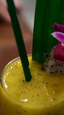 Cam kavanozda, mavi arka planda mangolu yoğurtlu smoothie dolduruyorum. Soğuk ve sağlıklı karışımlı Mango Lassi. Yüksek kalite 4k görüntü