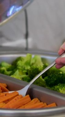 Açık büfede kaynamış havuç ve brokoli ahşap bir tahtanın üzerindeki mükemmel küplerde salata, çorba ve gurme tarifleri için profesyonel bıçak tekniğini gösteriyor. Yüksek kalite 4k görüntü